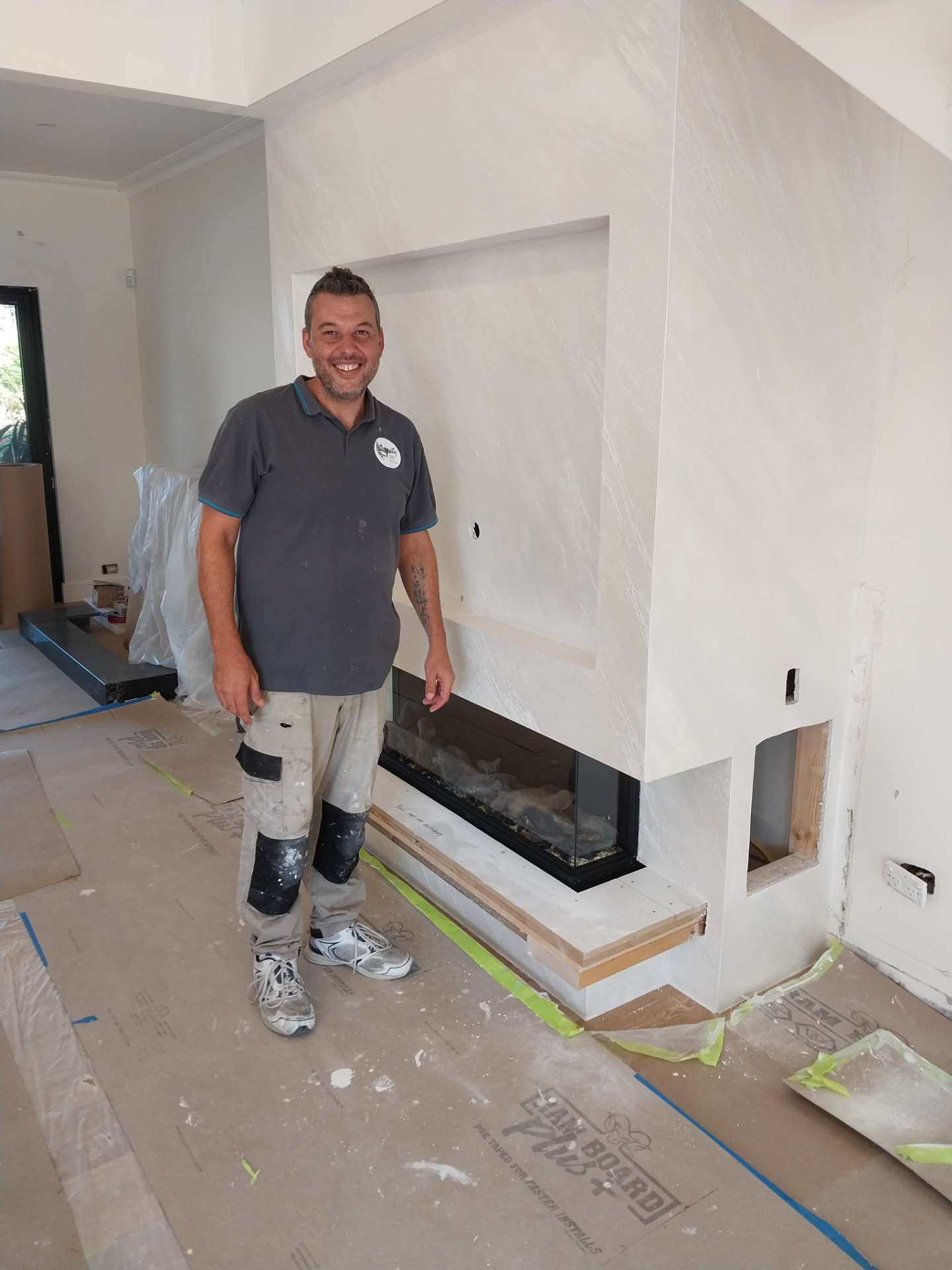 Federico standing beside a Venetian plaster media wall with inset fireplace