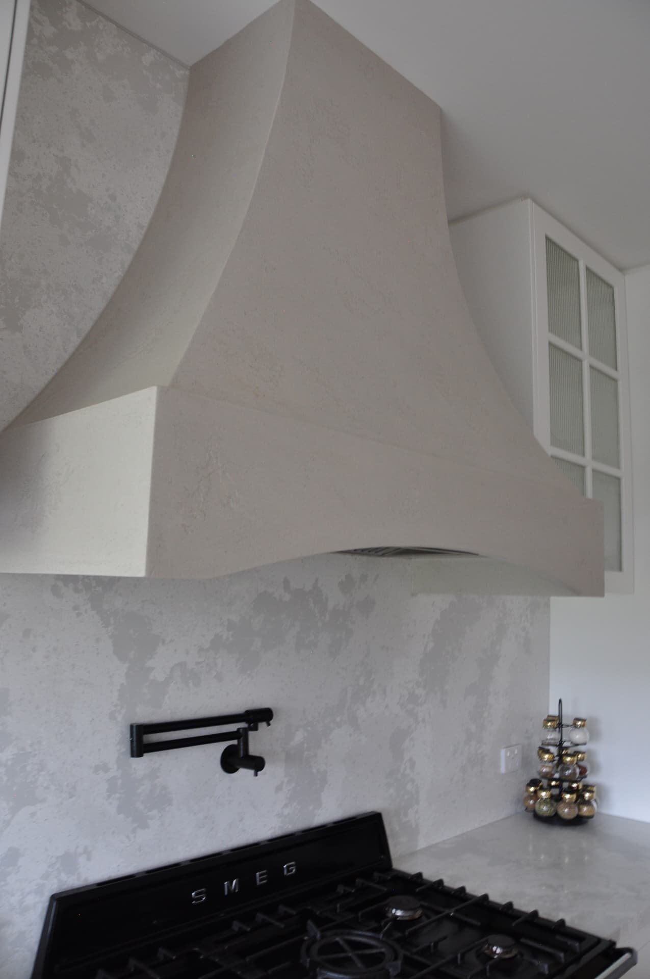 Venetian plaster range hood and kitchen splashback